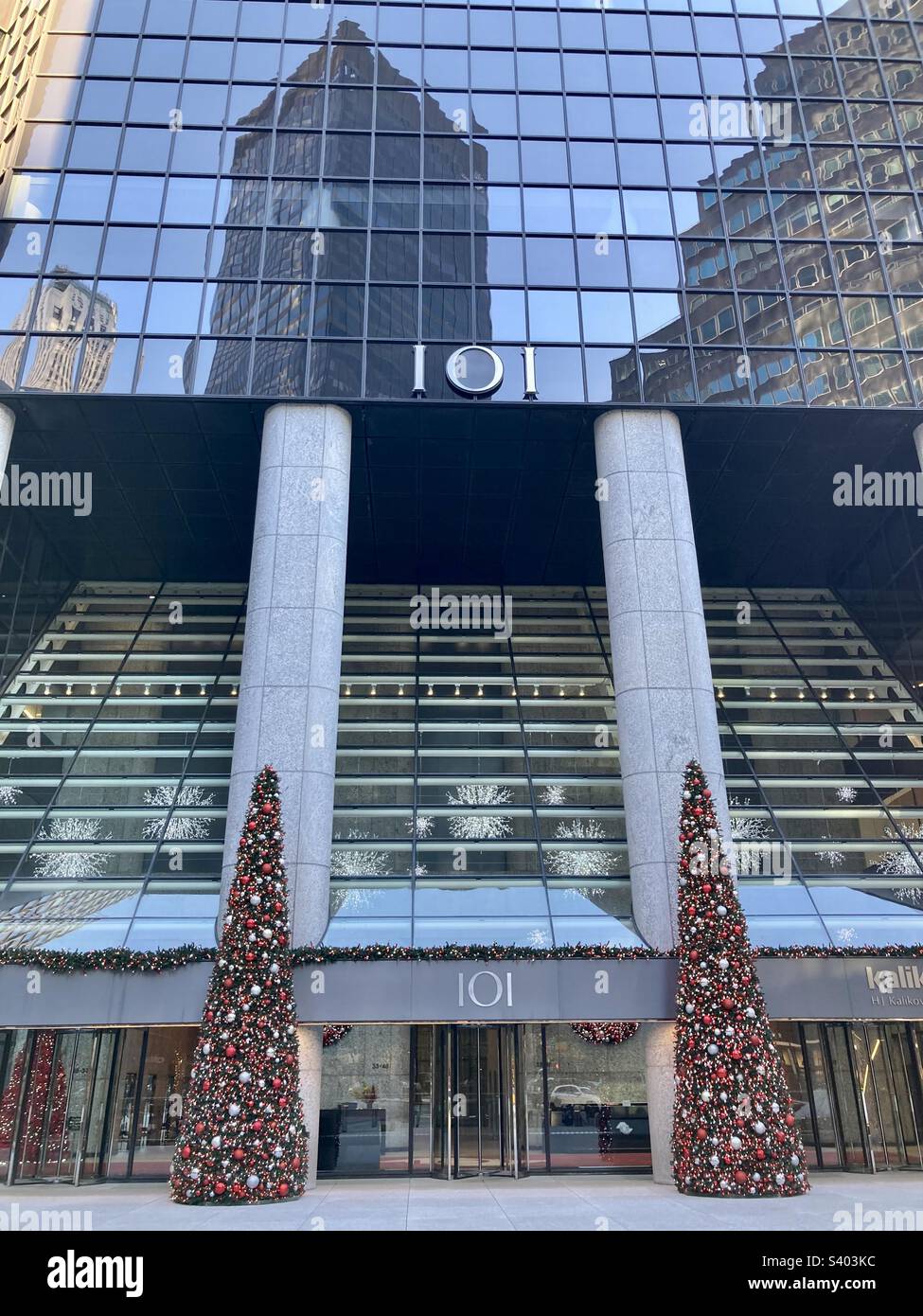 New York, New York, USA – 26. November 2022: Blick auf das Gebäude der Park Avenue 101 mit Weihnachtsbäumen bei Nacht. Es gibt auch eine Reflexion von anderen Gebäuden in den Fenstern darüber. (Redaktionell) - Smartphone-aufgenommenes Stockfoto