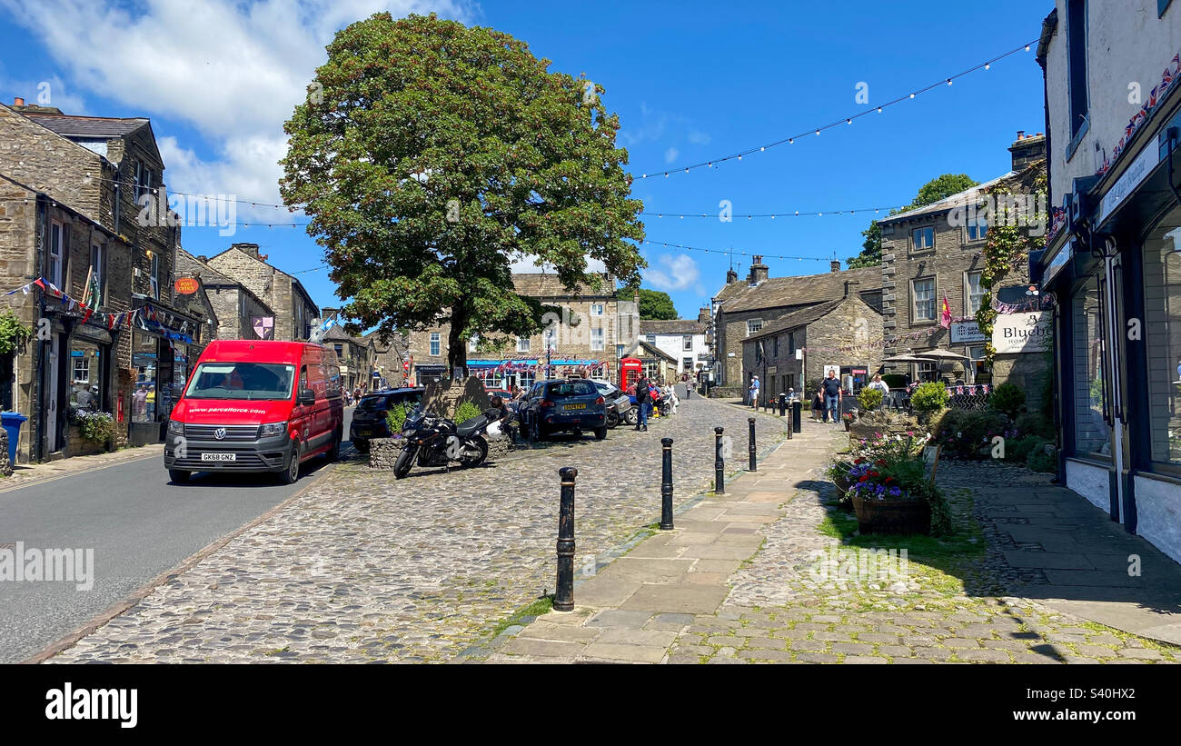 Die Sommersonne zieht viele Besucher nach Grassington Town, Yorkshire, Großbritannien - Smartphone-aufgenommenes Stockfoto