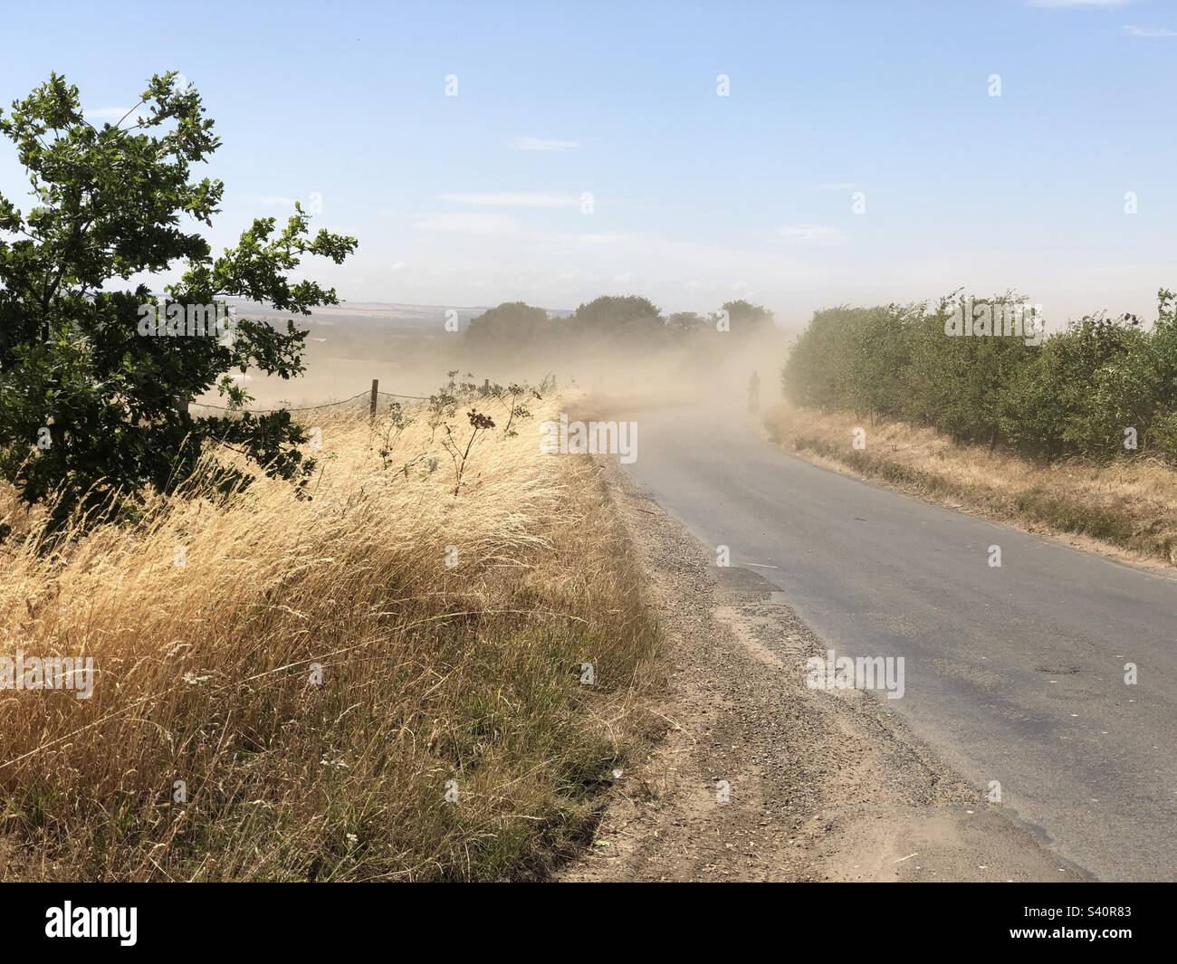 Ein Radfahrer, der während der schweren Dürre von 2022 durch einen Staubsturm in den Chilterns fuhr. - Smartphone-aufgenommenes Stockfoto