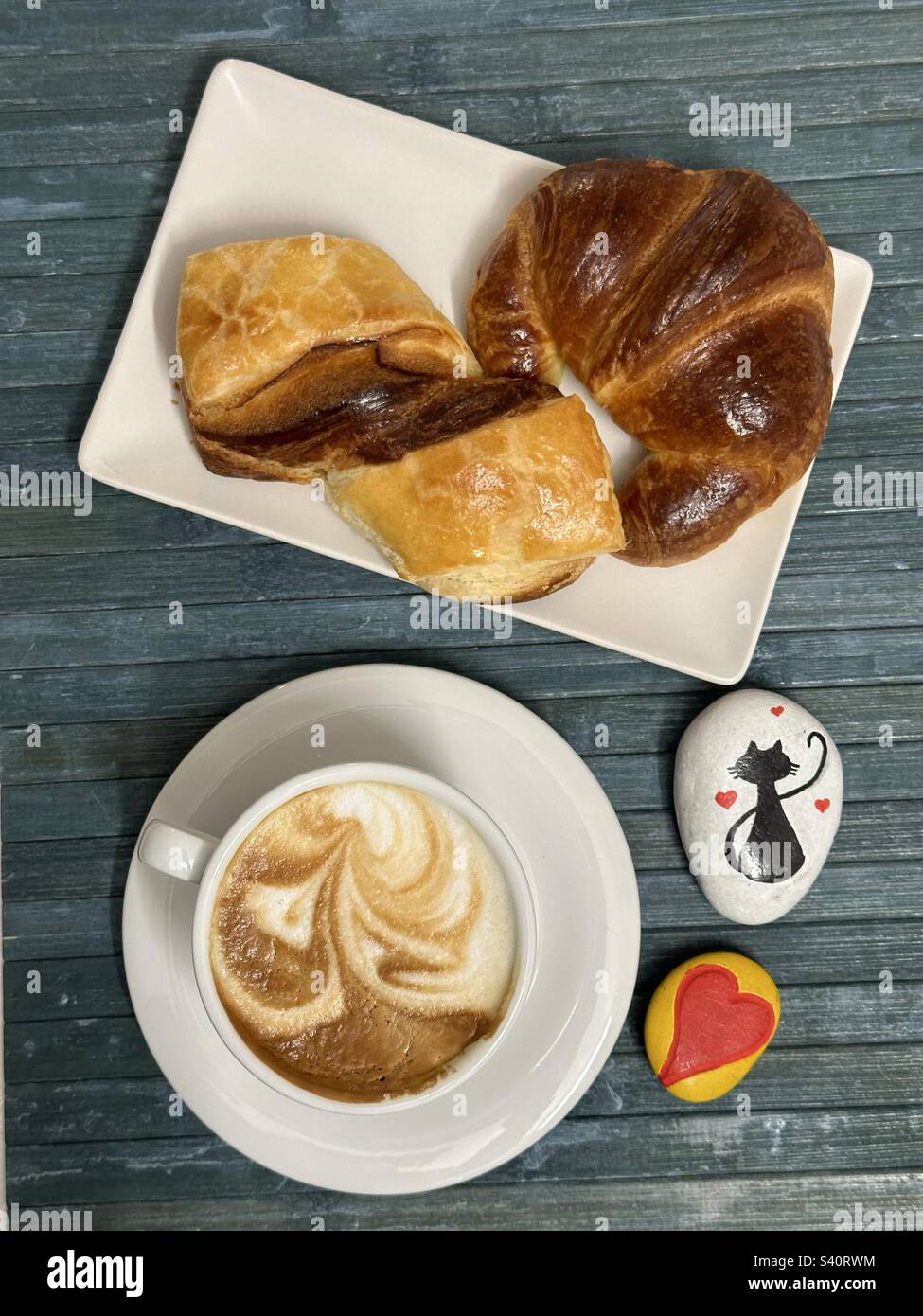 Das Frühstück an der Bar war herrlich und es gab einen Cappuccino, zwei Croissants und zwei künstlerische Steine Stockfoto