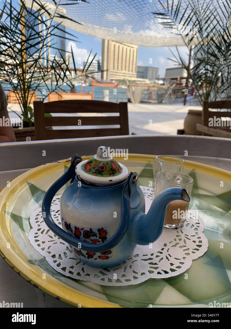 Nachmittagstee in einem Café mit Blick auf den Dubai Creek in den Vereinigten Arabischen Emiraten - Smartphone-aufgenommenes Stockfoto