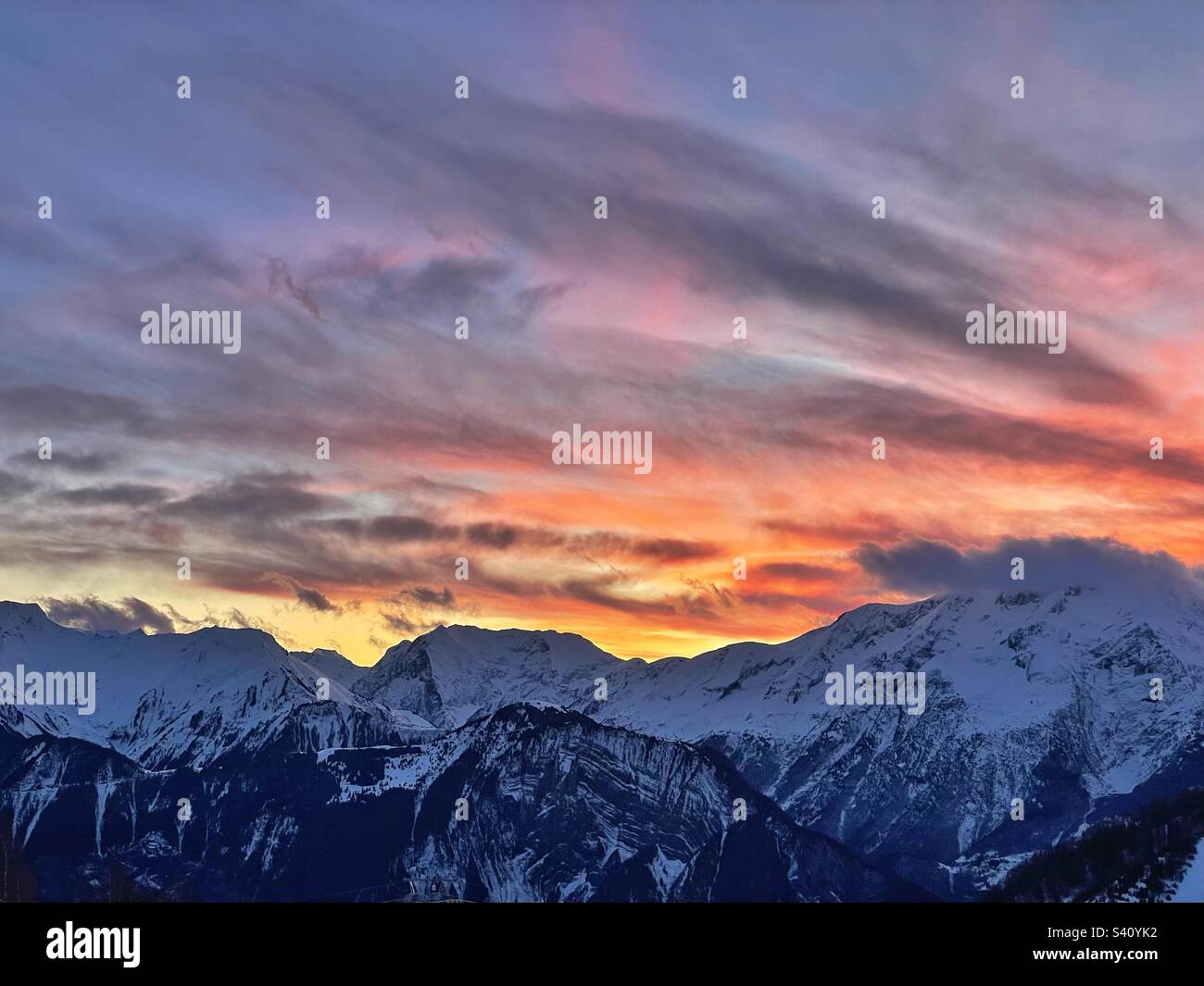 Sonnenuntergang über den verschneiten französischen Alpen ab Alpe d'Huez. Stockfoto