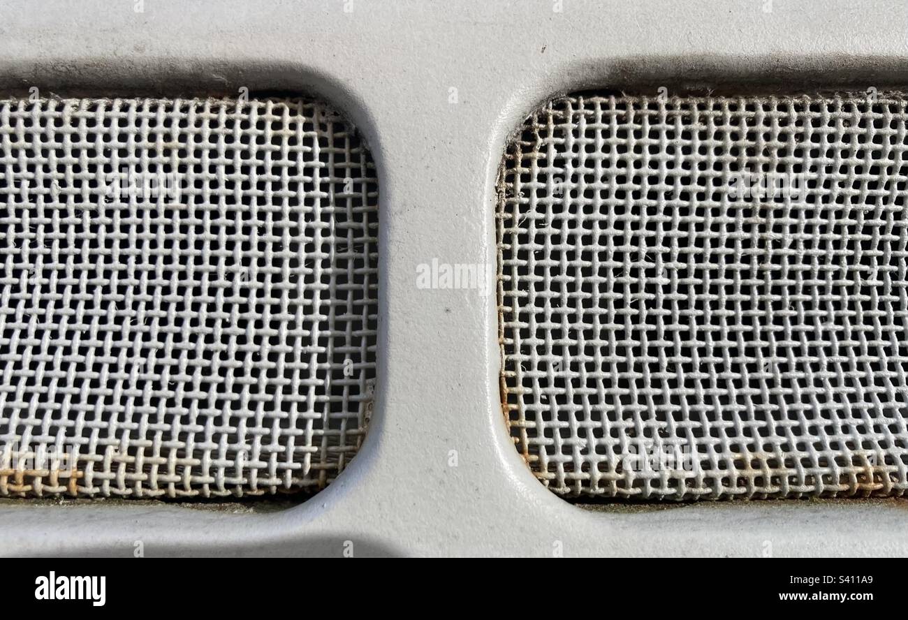 Ein grau lackiertes Metallgitter mit Rostflecken Stockfoto