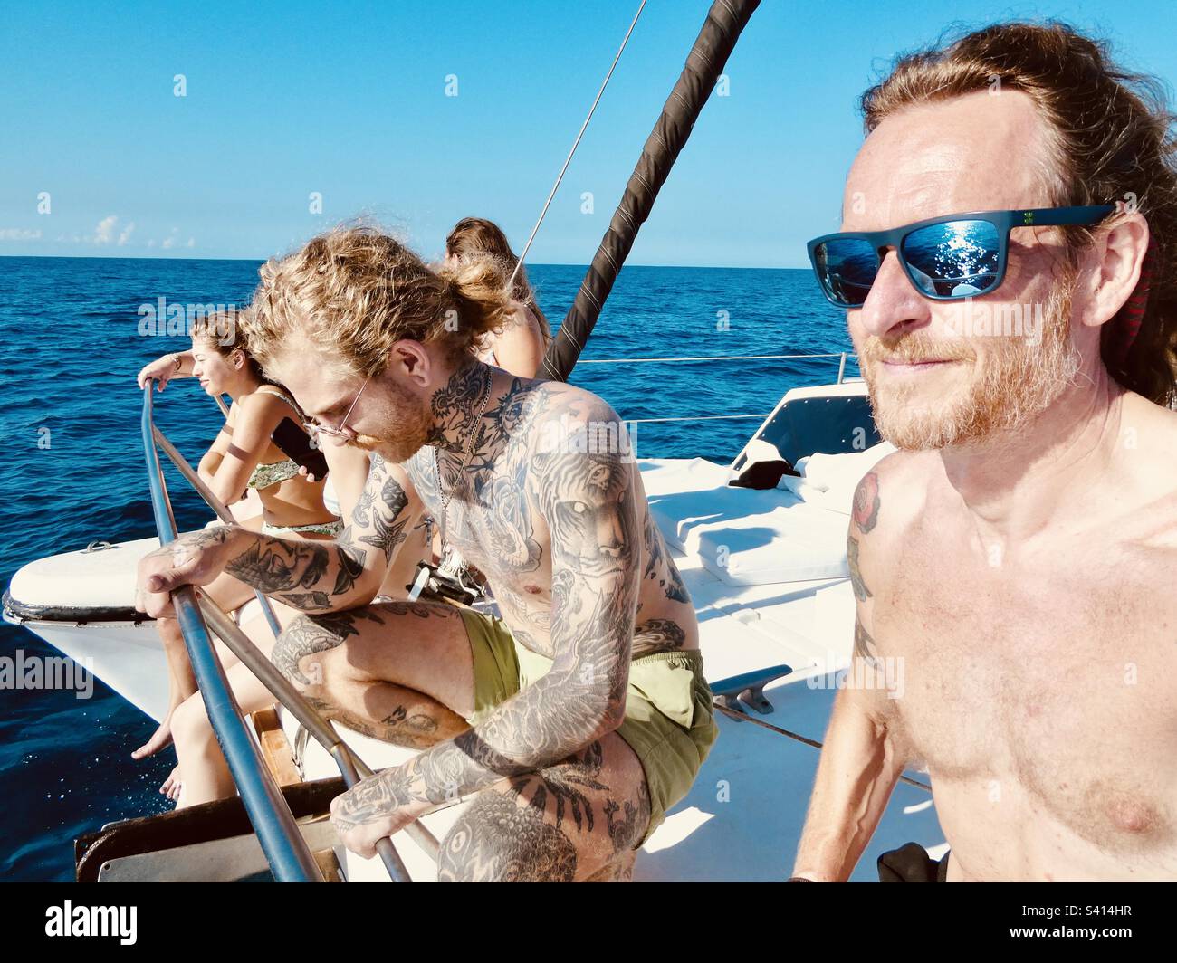 Reisende genießen es, an einem perfekten Tag in Costa Rica auf dem Deck eines Katamaranboots zu sitzen - Smartphone-aufgenommenes Stockfoto