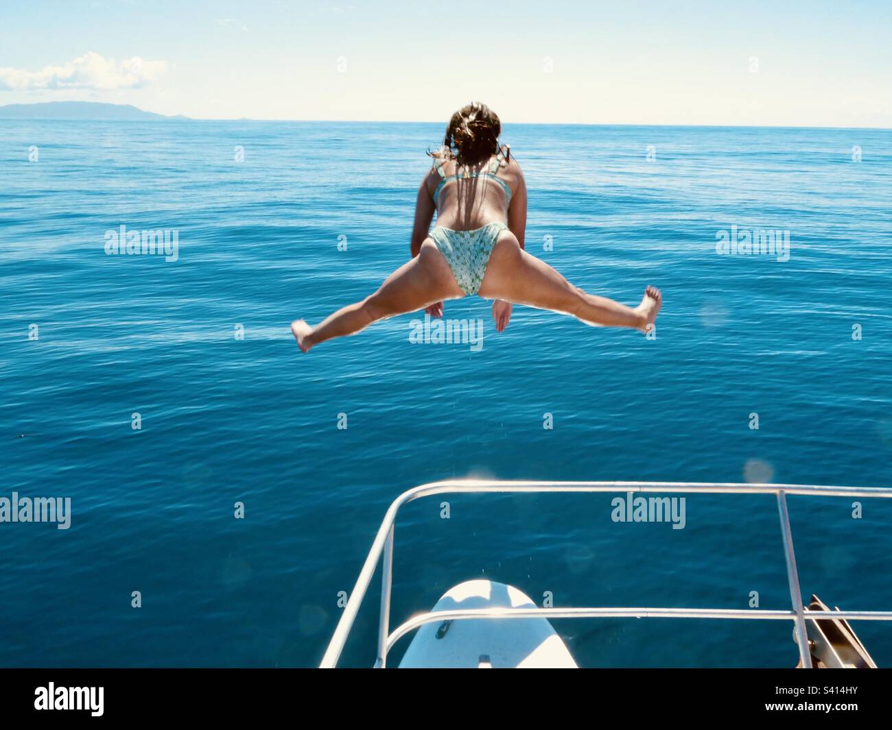 Eine Frau macht die Spaltungen, wenn sie von einem Boot in Costa Rica springt - Smartphone-aufgenommenes Stockfoto