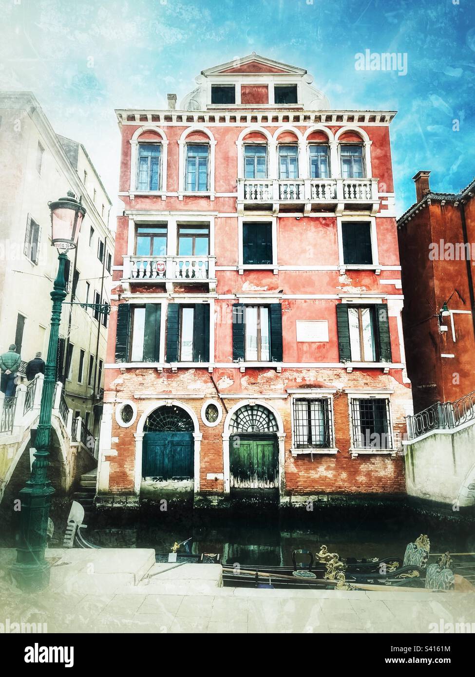 Historischer Palast in Venedig mit blauen und grünen Türen und einer kunstvoll verzierten Gondel vor dem engen Kanal. Bearbeitung in Not. Stockfoto
