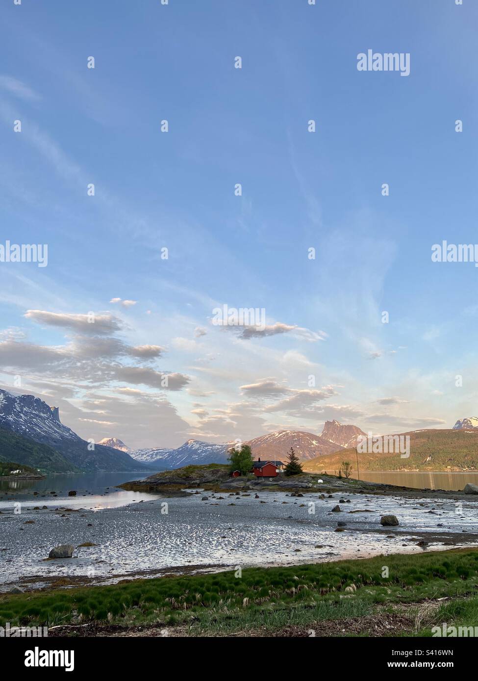 Foto eines Hauses auf einer kleinen Insel im Fjord Skjomen (Teil von Ofotfjorden) in Nordland, Nordnorwegen an einem sonnigen Sommerabend. Stockfoto