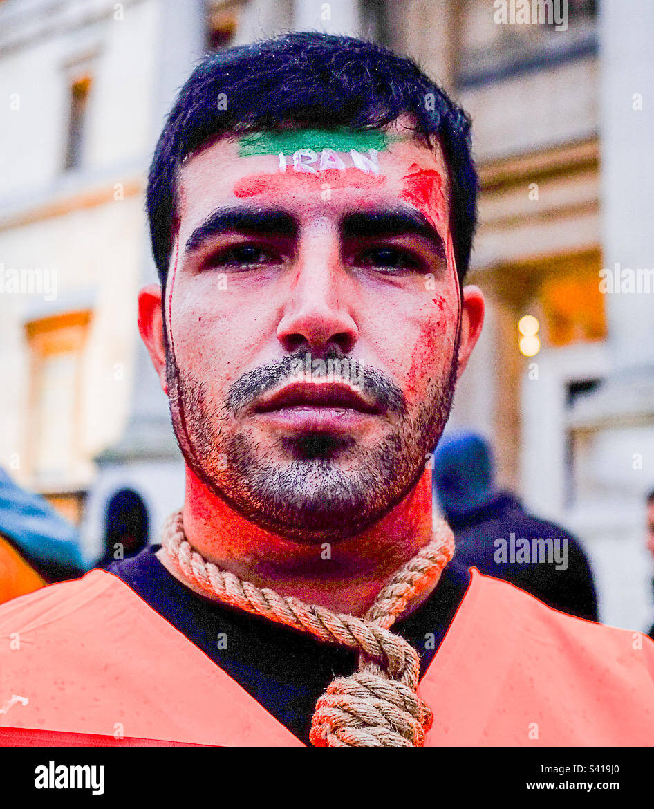 Iranischer Demonstrant mit einer Flagge auf seinem Gesicht und einem Hinrichtungsseil um seinen Hals Stockfoto