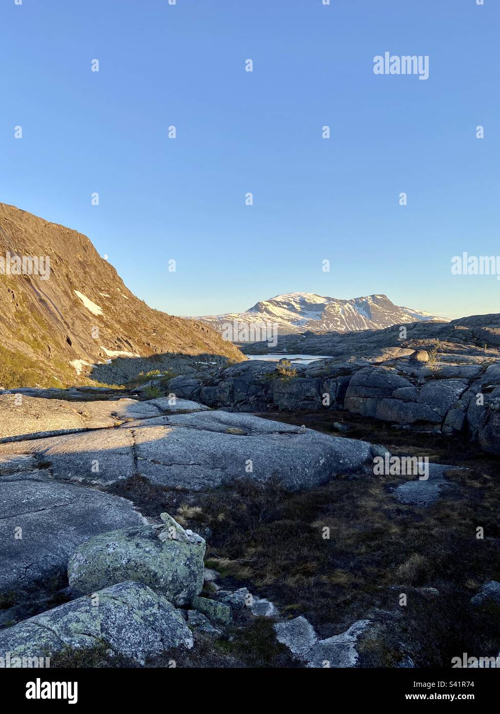 Berglandschaft in Nordnorwegen, aufgenommen im Juni 2022. Es gibt keine Wolken am Himmel und die Mitternachtssonne scheint. - Smartphone-aufgenommenes Stockfoto