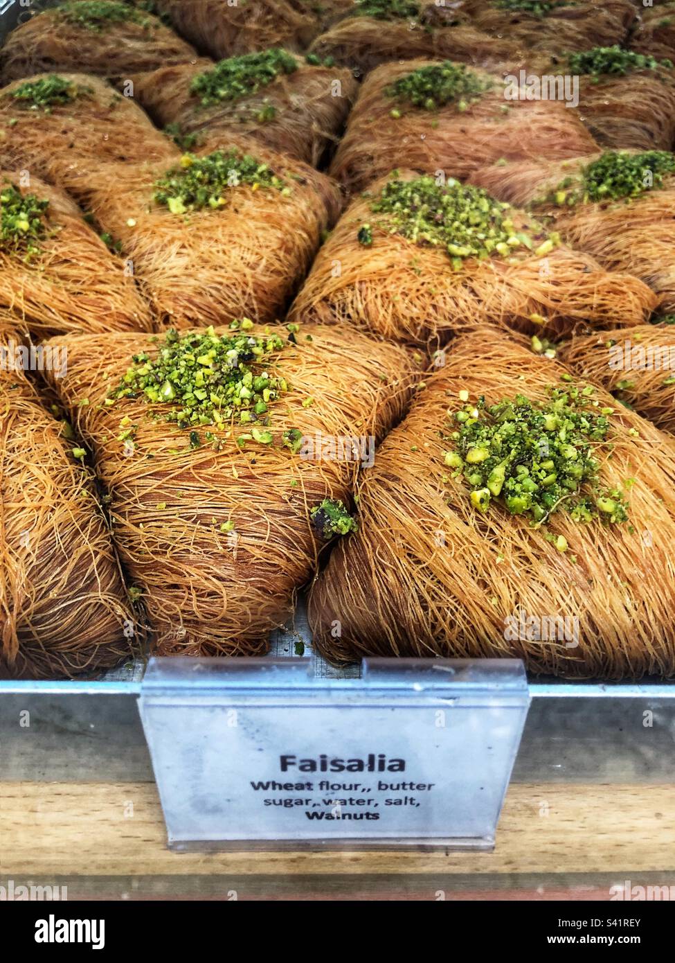 Faisalia oder Faisalia, ein dreieckiges Baklava mit einer Außenseite aus Fäden aus Kataifi-Teig und einer Füllung aus Pistazien oder Walnüssen, ein syrisches und nahöstliches Süßigkeiten in der Bäckerei Stockfoto