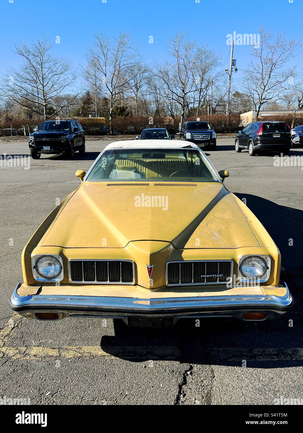 Ein altes gelbes Pontiac-Auto auf einem Parkplatz in New York, USA. - Smartphone-aufgenommenes Stockfoto