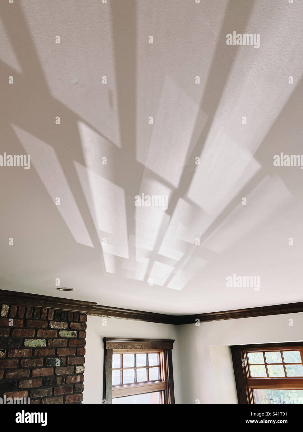 Innenaufnahme von Reflexionen und Lichtspiel, das auf die Decke eines Wohnzimmers prallt. Stockfoto