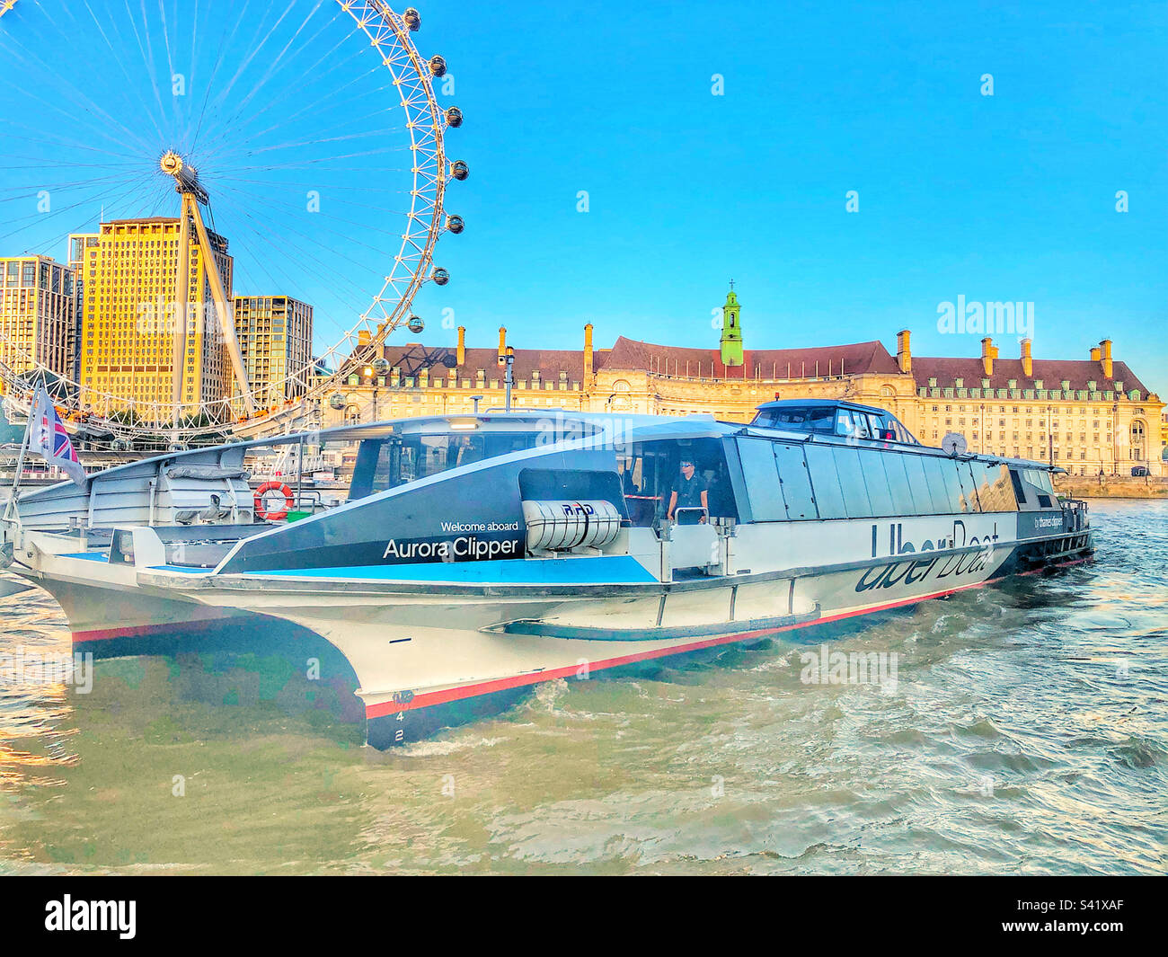 Blick auf das London Eye mit einem Uber-Boot im Vordergrund Stockfoto
