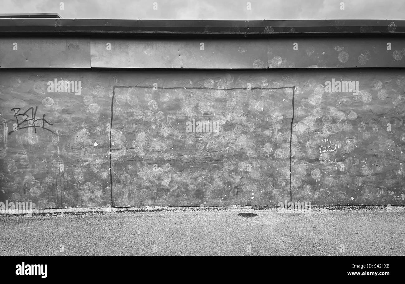„Verlagerung der Torpfosten“ handgezeichnete Torpfosten, die an eine Wand graffiert sind. Schlammige Ballspuren von Schüssen (einige auf dem Ziel, andere nicht) werden von den Spielen „Gone By“ (Schwarz und Weiß) zurückgelassen. Stockfoto