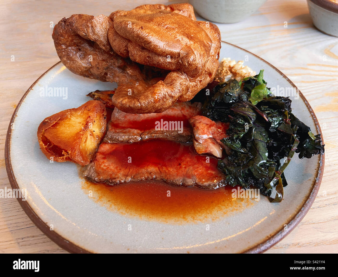 Roastbeef Sonntagsessen auf einem Teller. Es gibt einen großen Yorkshire Pudding. - Smartphone-aufgenommenes Stockfoto
