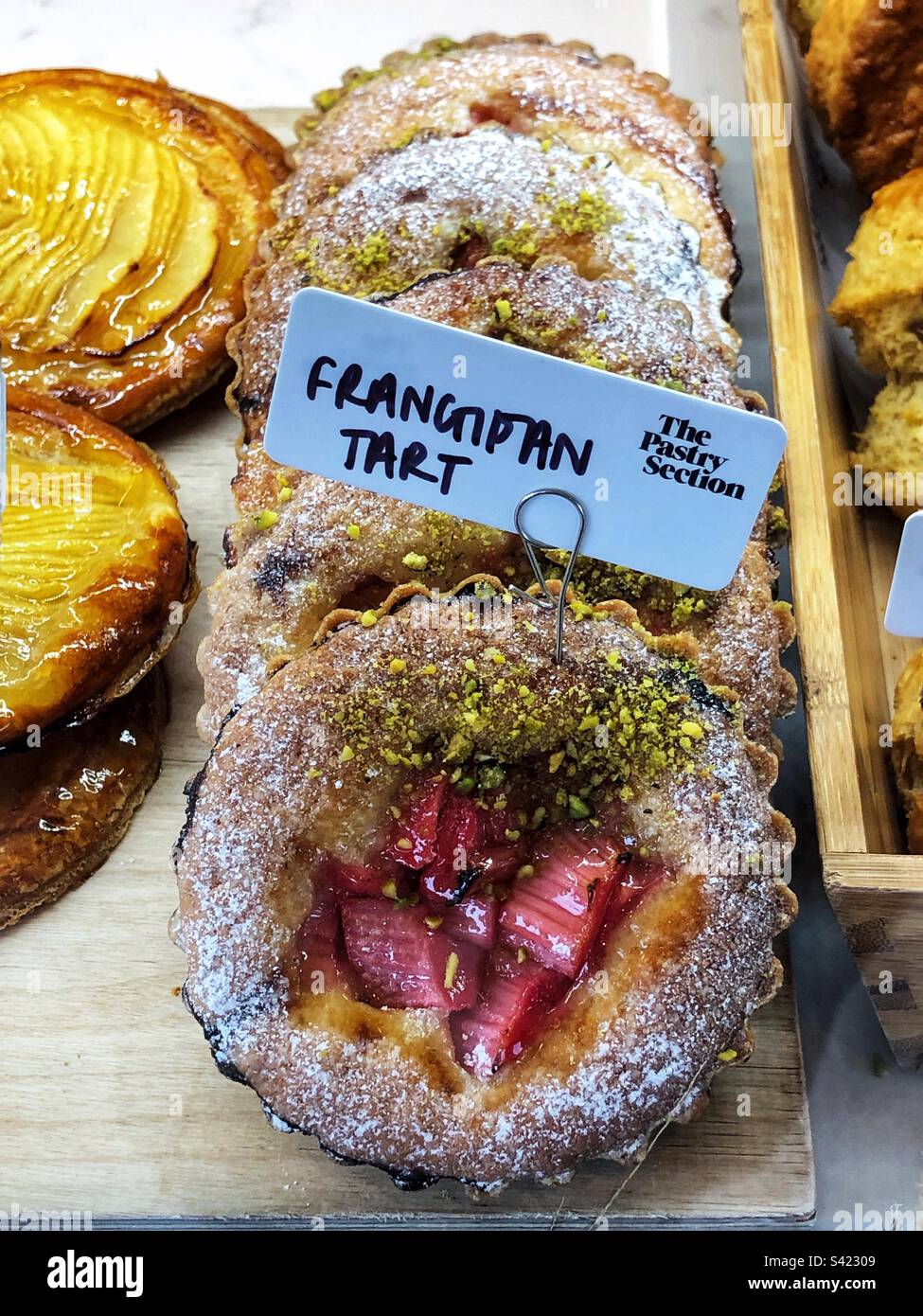 Frangipantörtchen im Fenster der Bäckerei Stockfoto