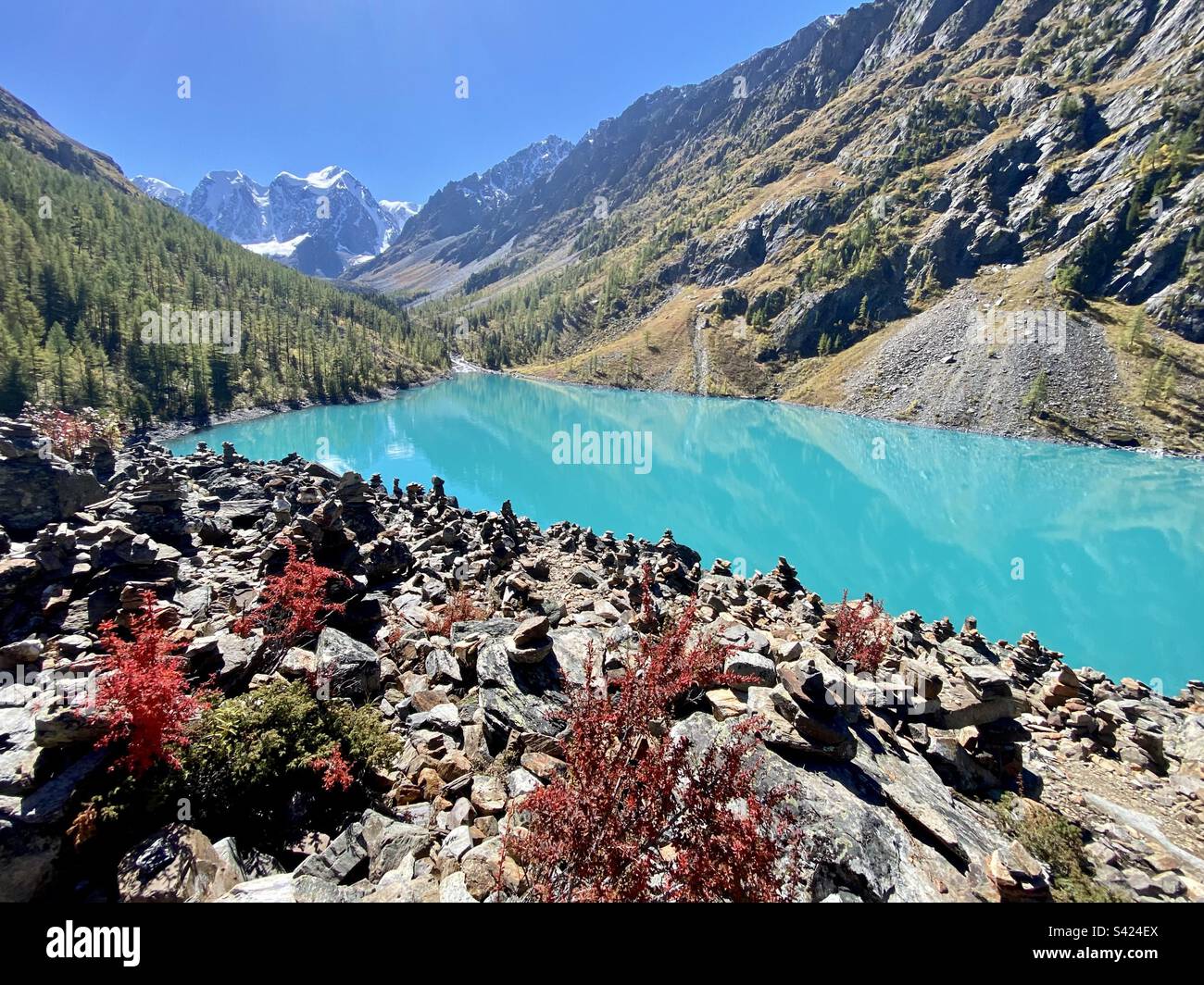 Steinsäulen am Ufer des alpinen türkisfarbenen Sees Shavlinskoye in den Bergen mit Gletschern im Altai in Sibirien. Stockfoto