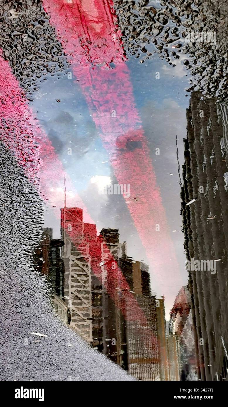 Die Reflexion der Wolkenkratzer der Stadt auf der Wasserpfütze Stockfoto