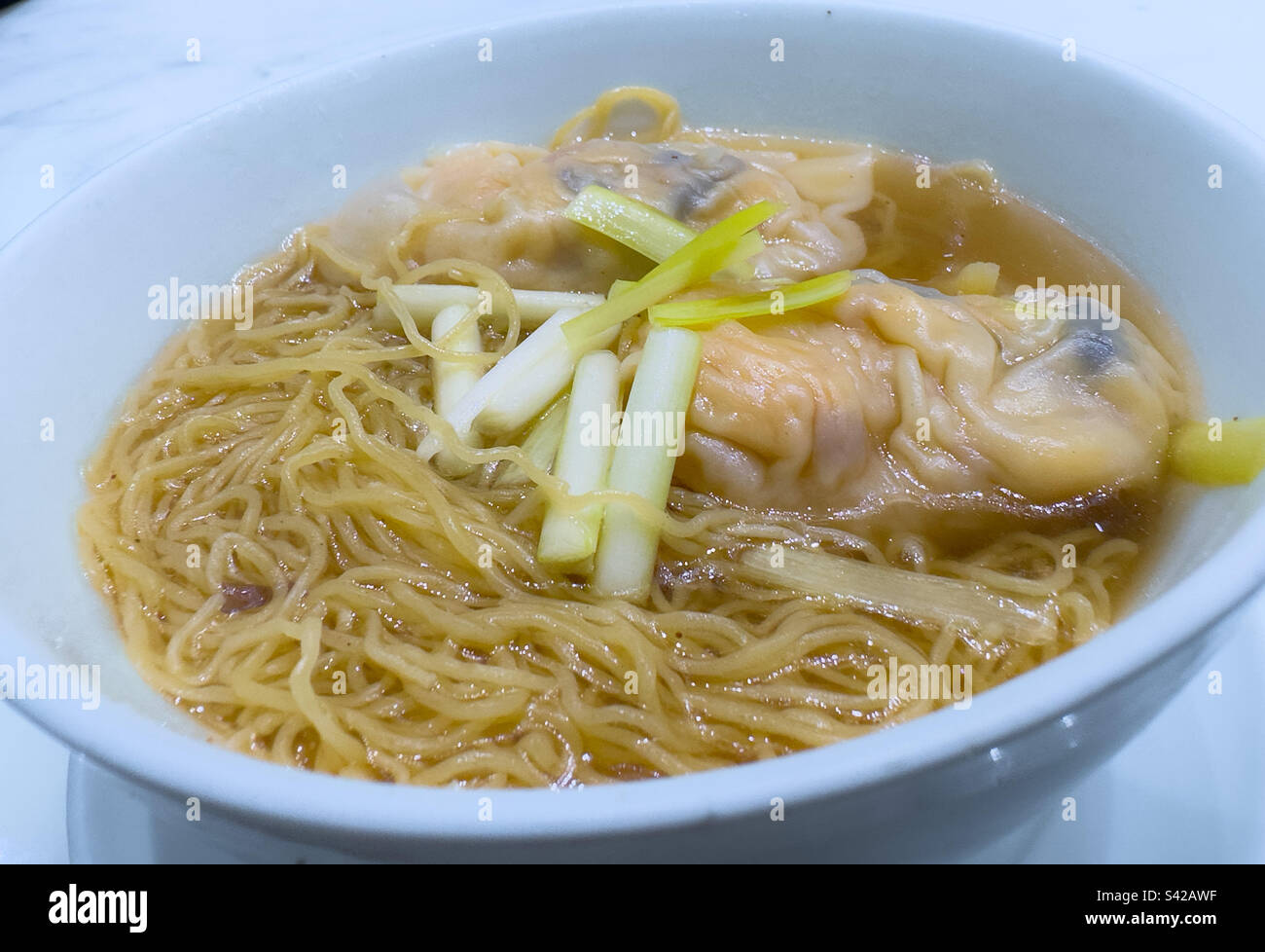 Schüssel mit dampfenden heißen Wonton- und Sui-Gow-Nudelsuppe, der König der kulinarischen Köstlichkeiten der kantonesischen Küche - Smartphone-aufgenommenes Stockfoto