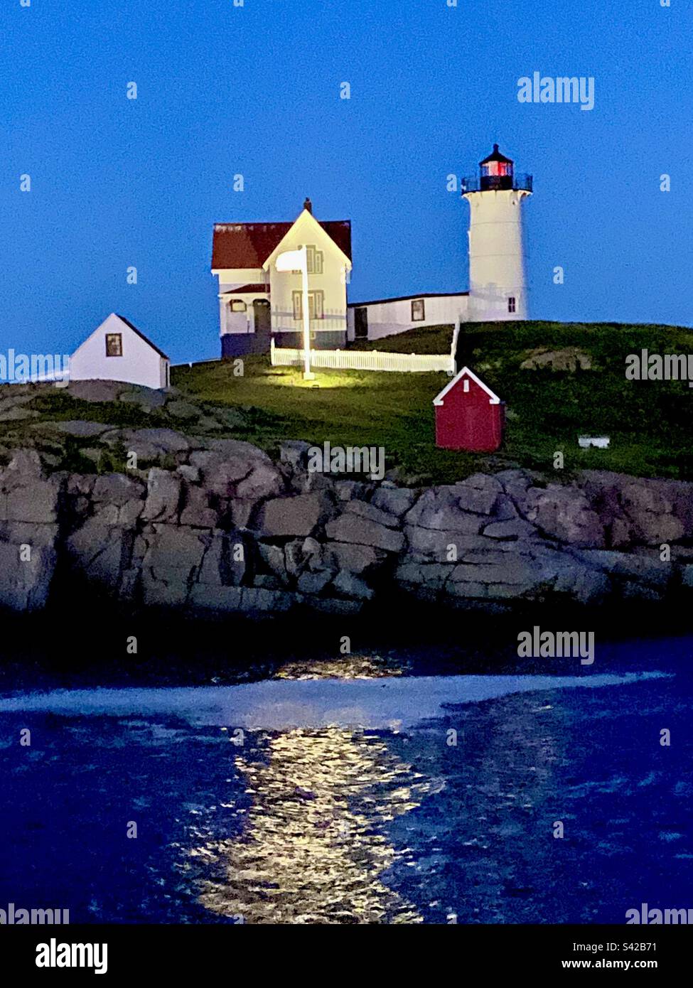 Abendliche Reflexionen über das Wasser im Nubble Lighthouse, York, Maine Stockfoto