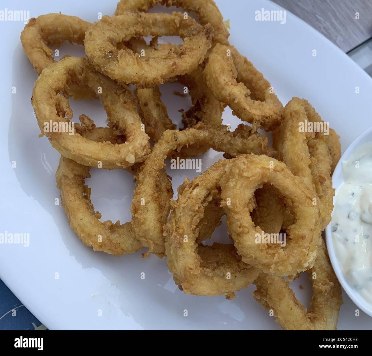 Nahaufnahme von gebratenen Calamari-Ringen serviert mit Tartarsauce Stockfoto