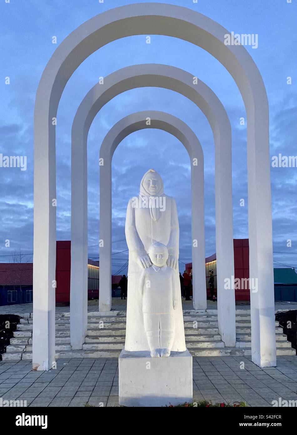 Denkmal die Statue „Mutterland“ in Form einer Frau in einem Kopftuch mit einem Kind leuchtet unter dem Bogen im Victory Park in Russland. Stockfoto