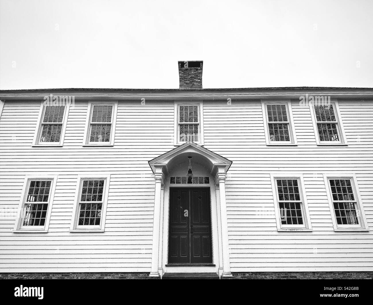 Schwarzweißfoto eines zweistöckigen Kolonialhauses in Glastonbury, Connecticut, USA, an einem bewölkten Tag Stockfoto