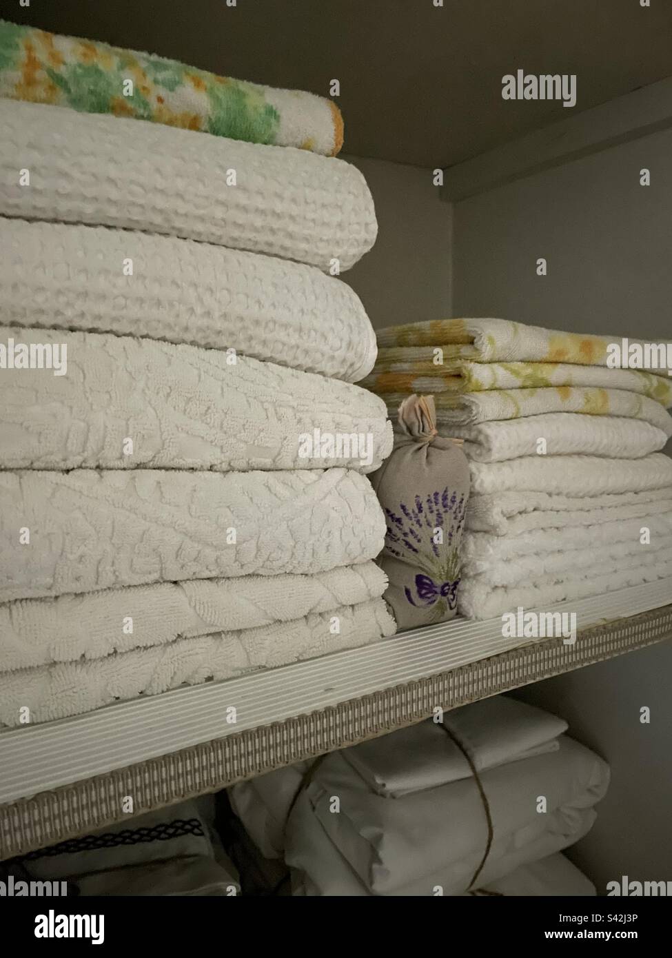 Ein Stapel Bettwäsche auf einem Schrankregal Stockfoto