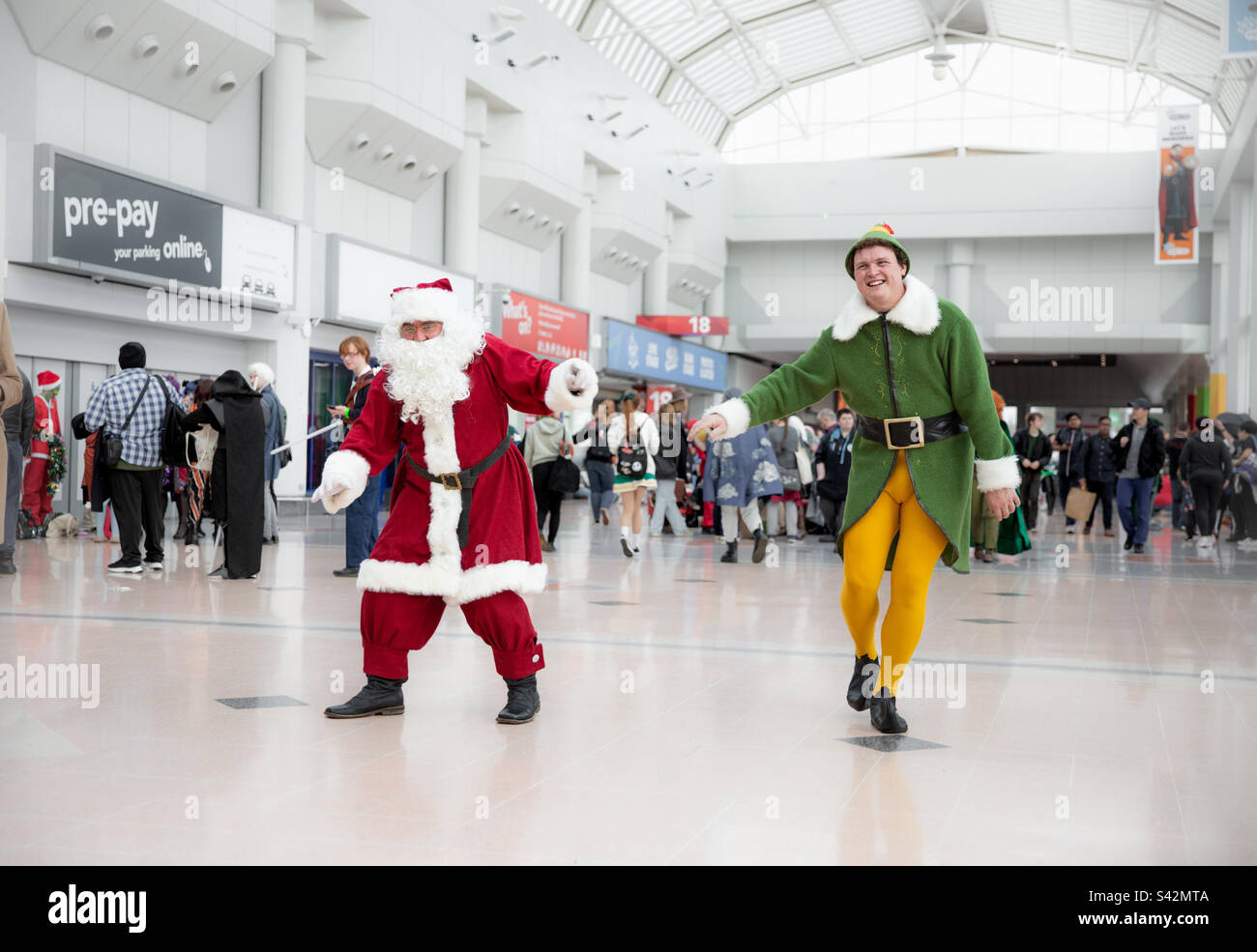 Männliche Cosplayers, verkleidet als Weihnachtsmann und Buddy der Elf bei einem Comic und amüsieren sich Stockfoto