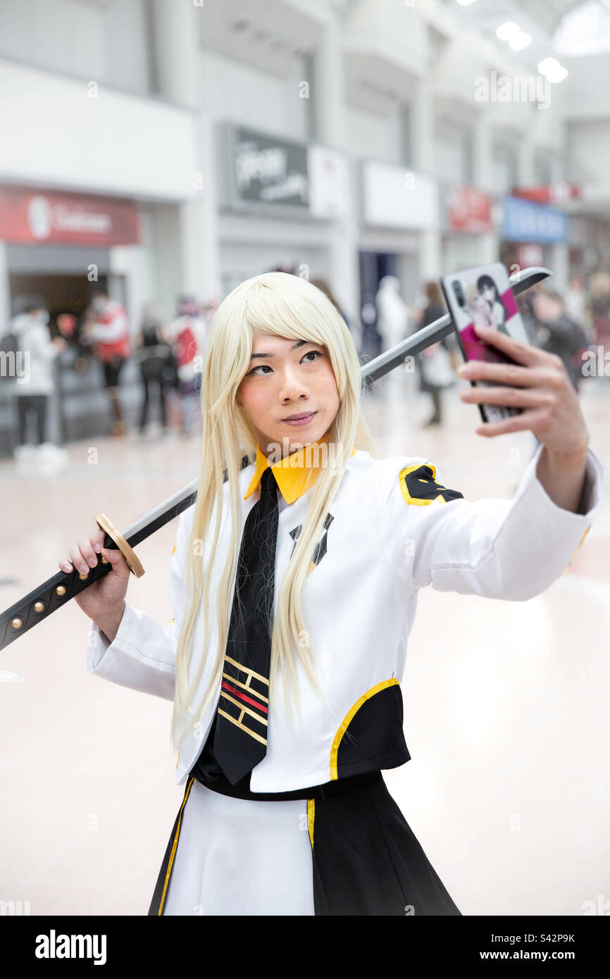 Ein junger koreanischer Cosplayer, verkleidet als Anime-Figur, der ein Selfie auf einem Mobiltelefon bei einem Comic-Con macht Stockfoto