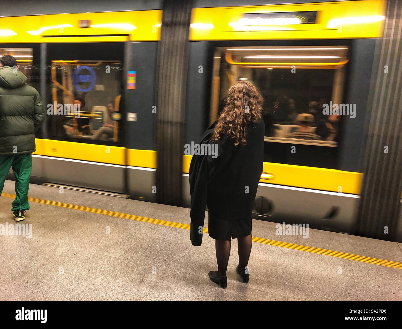 Eine Dame an der Trindade Station des U-Bahnnetzes von Porto wartet auf den Zug, der hält, Portugal, 2023 - Smartphone-aufgenommenes Stockfoto