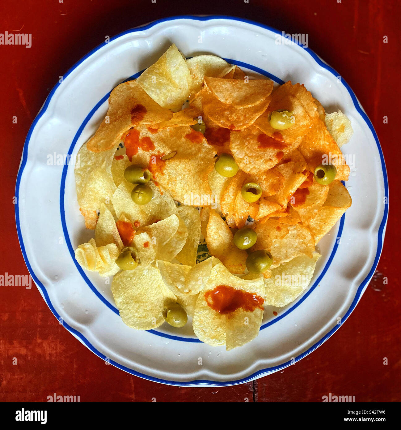 Gebratene Kartoffelchips mit roter scharfer Sauce und Oliven in Mexiko Stockfoto