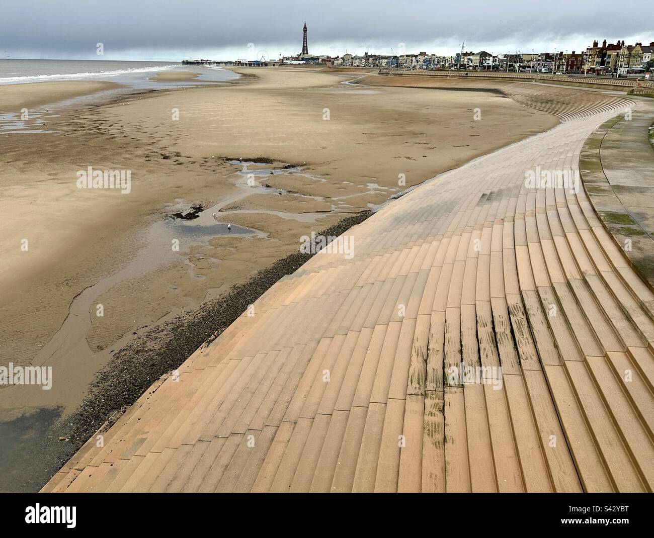 Die Aussicht vom Blackpool South Pier, über einen breiten Streifen von verlassenem Sand mit Blackpool Tower in der Ferne Stockfoto