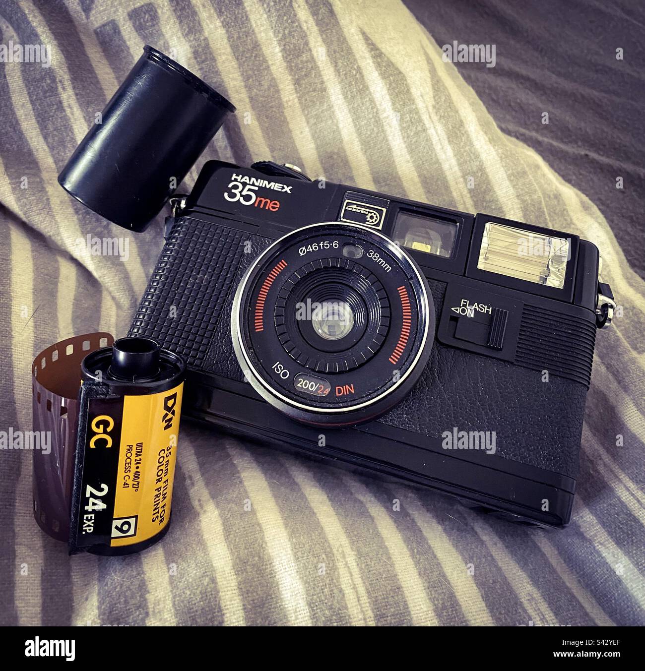 Eine alte alte 35mm-Kamera und eine Filmrolle, bereit für Fotos - Smartphone-aufgenommenes Stockfoto Eine alte alte 35mm-Kamera und eine Filmrolle, bereit für Fotos - Smartphone-aufgenommenes Stockfoto