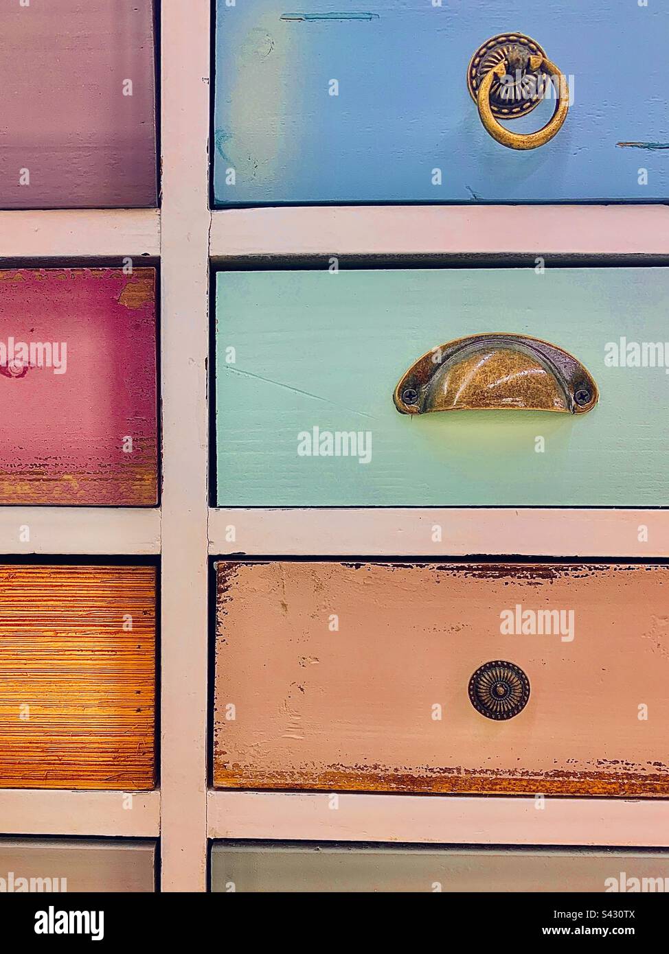 Farbenfrohes und einzigartiges Möbelstück mit nicht aufeinander abgestimmten Griffen und Knöpfen - Smartphone-aufgenommenes Stockfoto