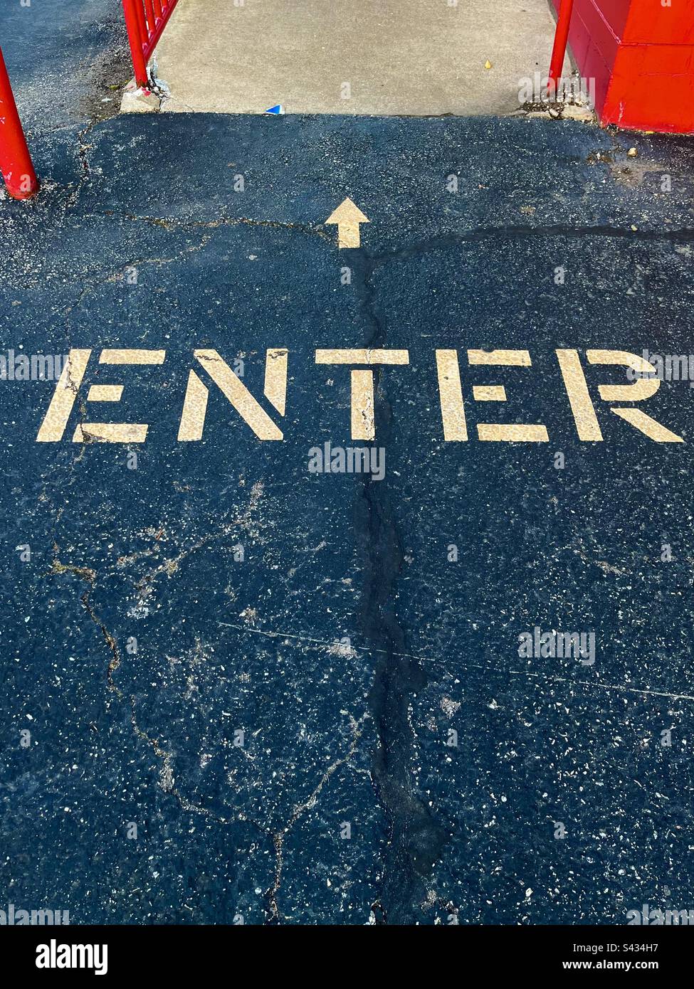 Einfacher Hintergrund für Asphalt mit roten Details, sagt „ENTER“ (EINGABE), in gelben Buchstaben mit Pfeil in Richtung. Einschließlich Druckbereich. Stockfoto