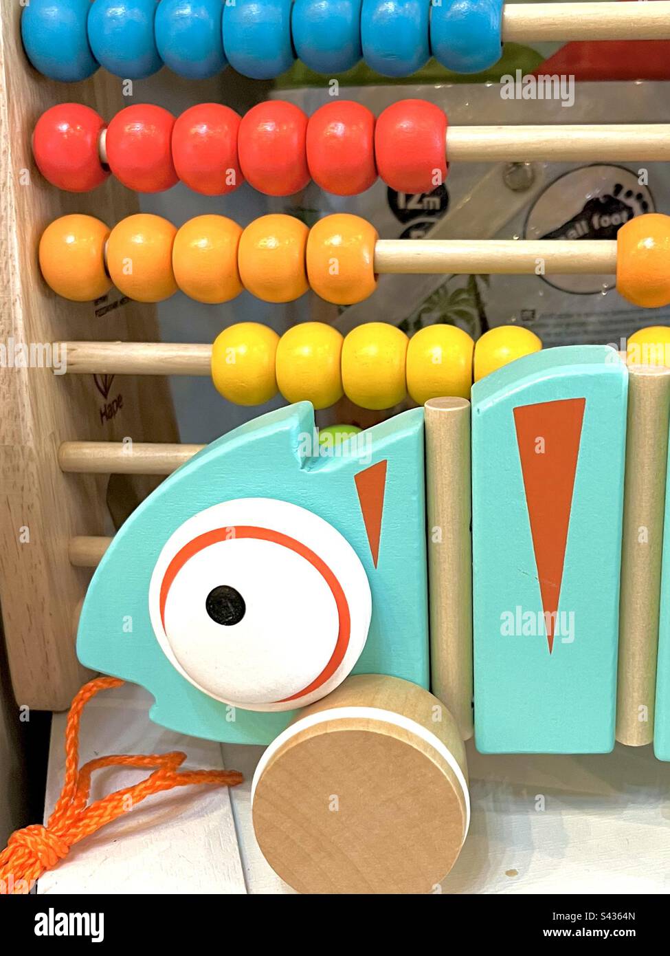 Spielzeuge für Kleinkinder. Farbenfrohes Zugspielzeug mit Abacus und Leguan. Stockfoto