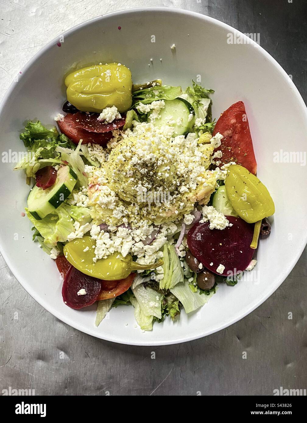 Griechischer Salat mit Kartoffelsalat, Feta, Paprika, Rüben, Oliven, Tomaten und Gurken Stockfoto