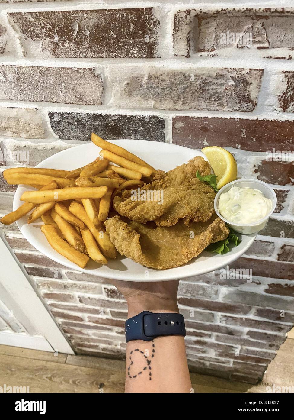 Fish and Chips mit Tartenteinsoße und einer Zitronenscheibe Stockfoto