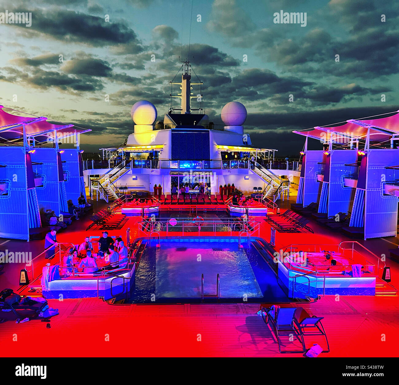 Lichter auf einem Kreuzfahrtschiff Pooldeck bei Nacht Stockfoto