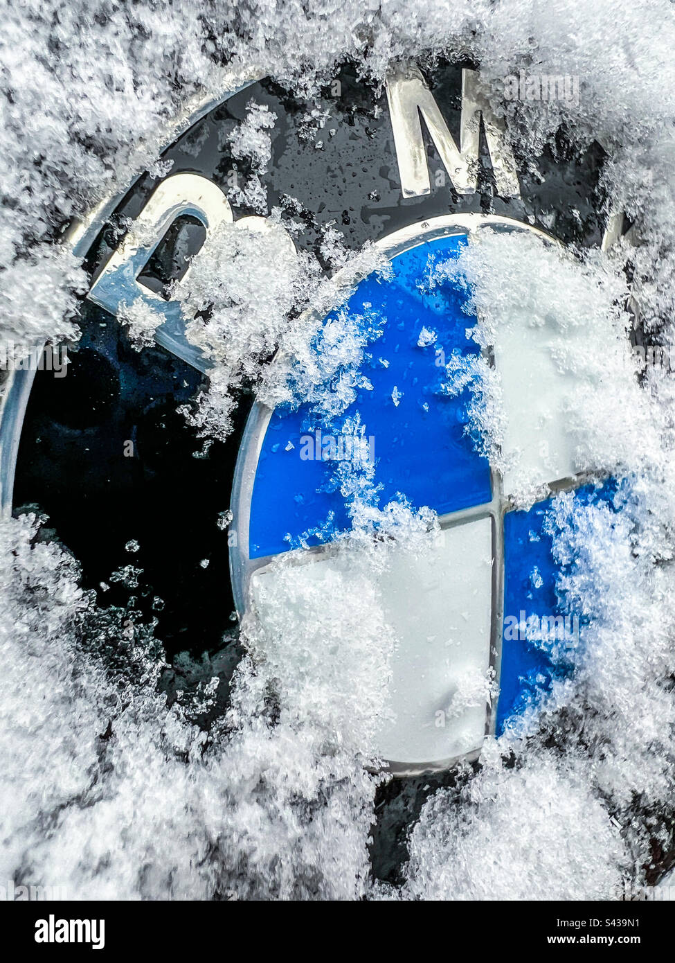 BMW-Logo teilweise mit Schnee bedeckt - Smartphone-aufgenommenes Stockfoto