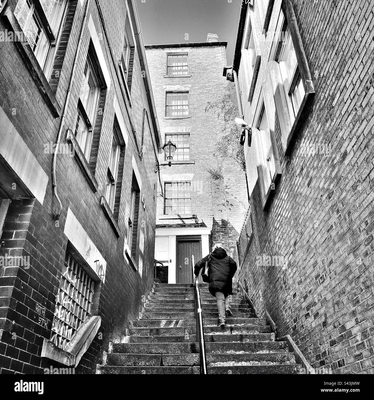 Eine Frau, die steile Stufen hinaufgeht Stockfoto
