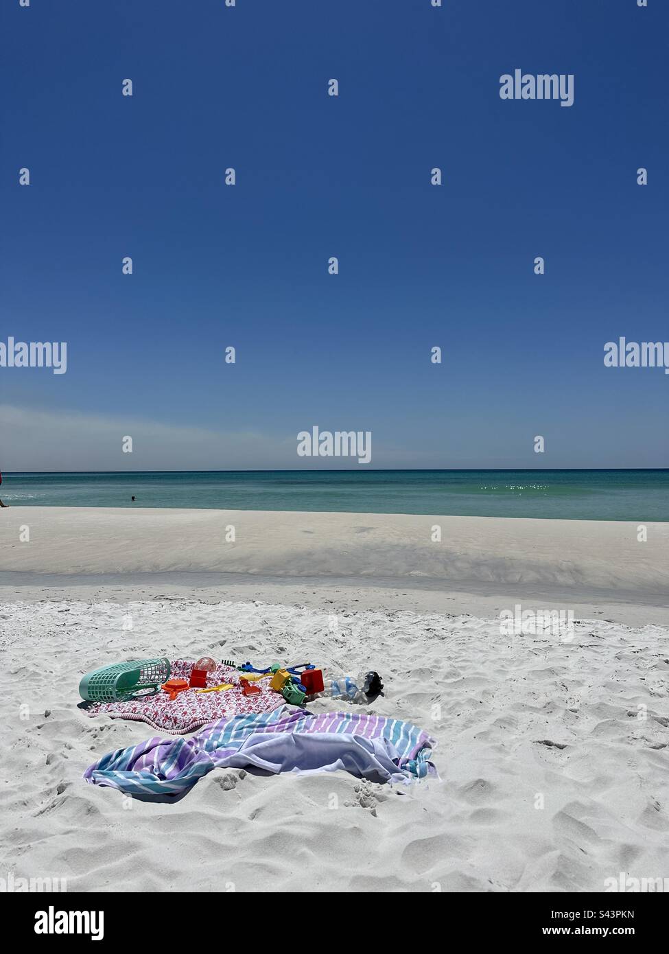 Auswahl an Strandspielzeug und Handtüchern am weißen Sandstrand Stockfoto