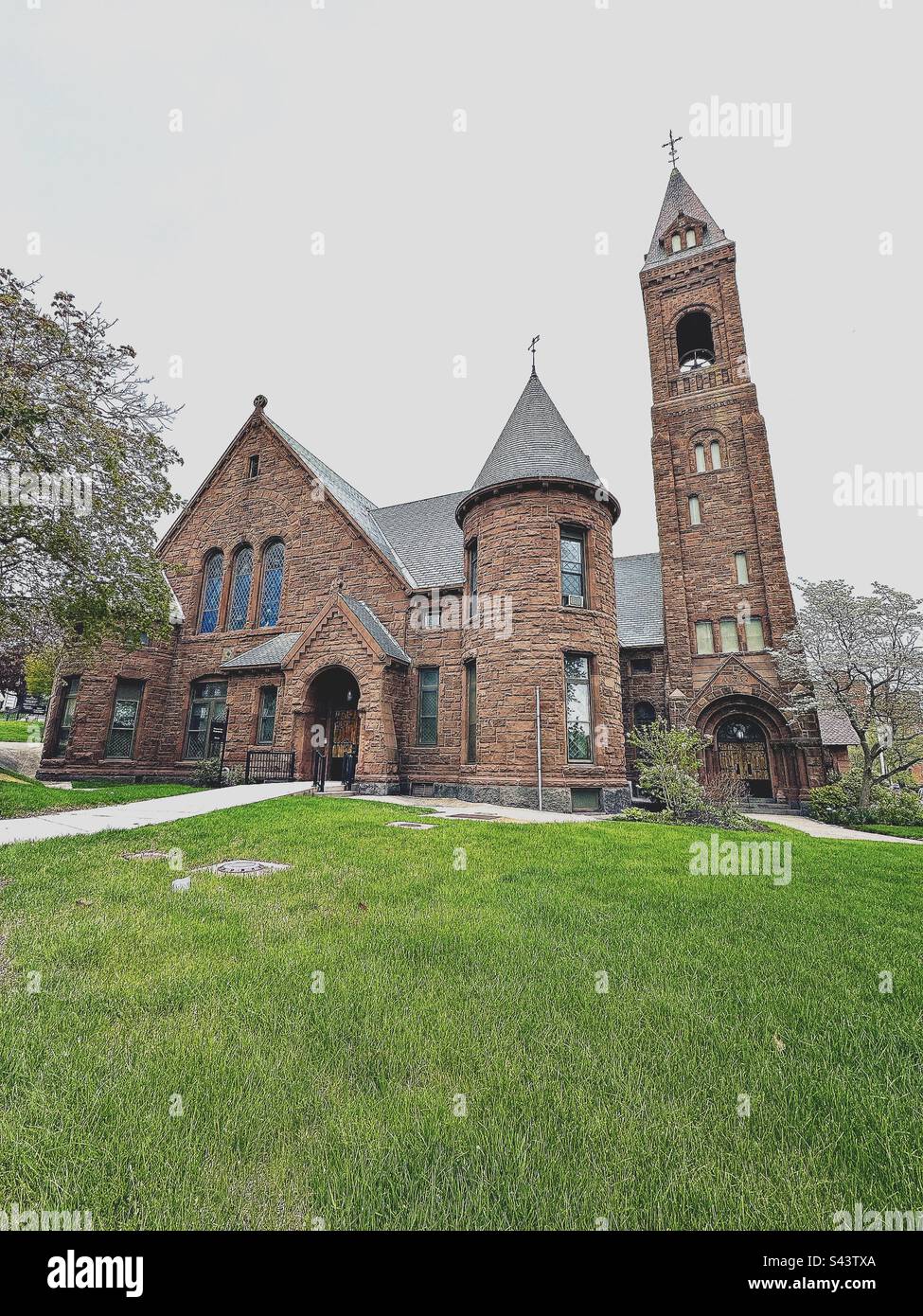 Worcester, Massachusetts, USA: Außenansicht der Worcester Area Mission Society mit grünem Gras im Vordergrund. Es war bewölkt, Frühlingstag. - Smartphone-aufgenommenes Stockfoto