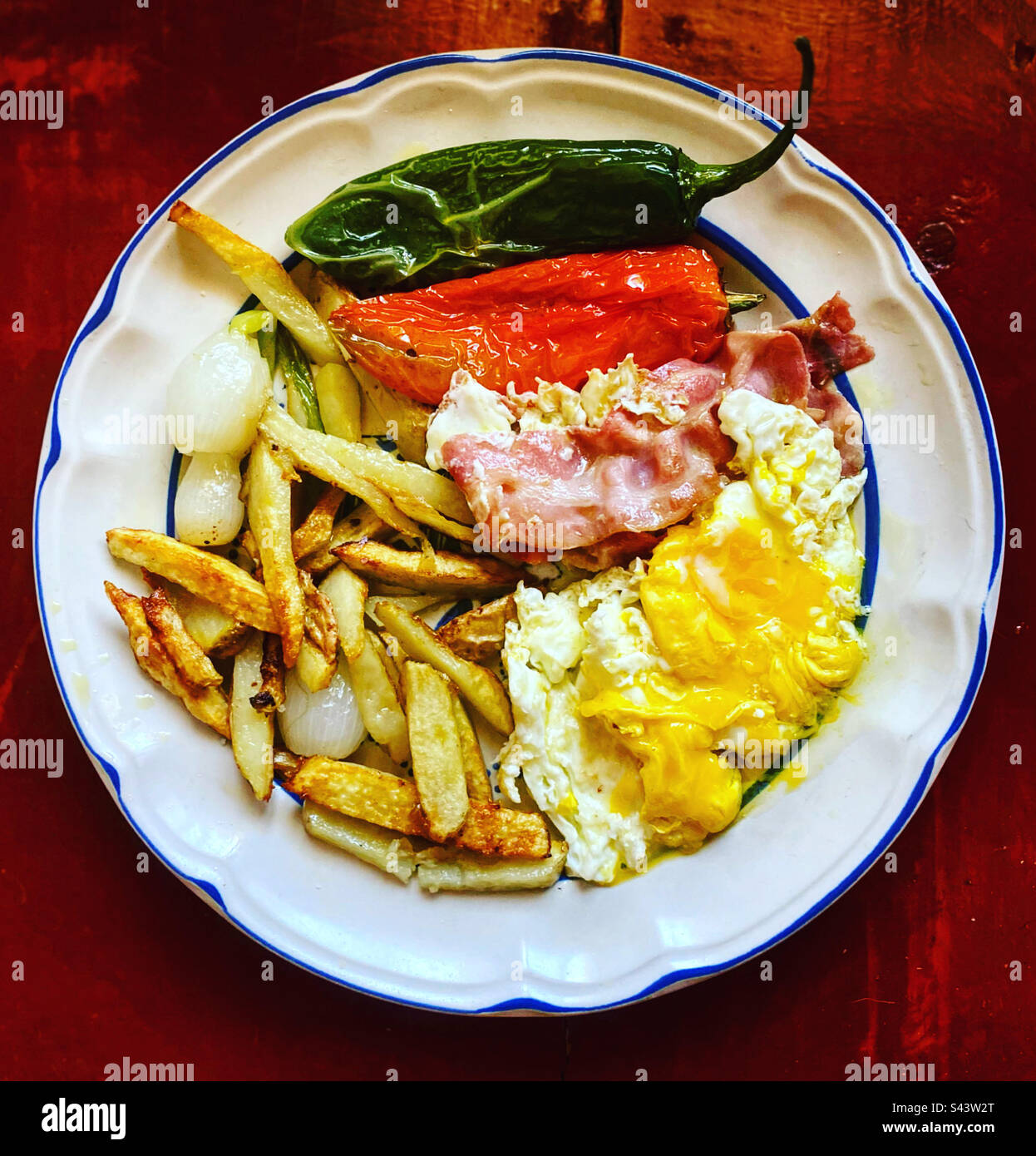 Zwiebeln, rote und grüne scharfe Chilis, Speck, Bratkartoffeln und Eier zum Frühstück in Queretaro, Mexiko Stockfoto