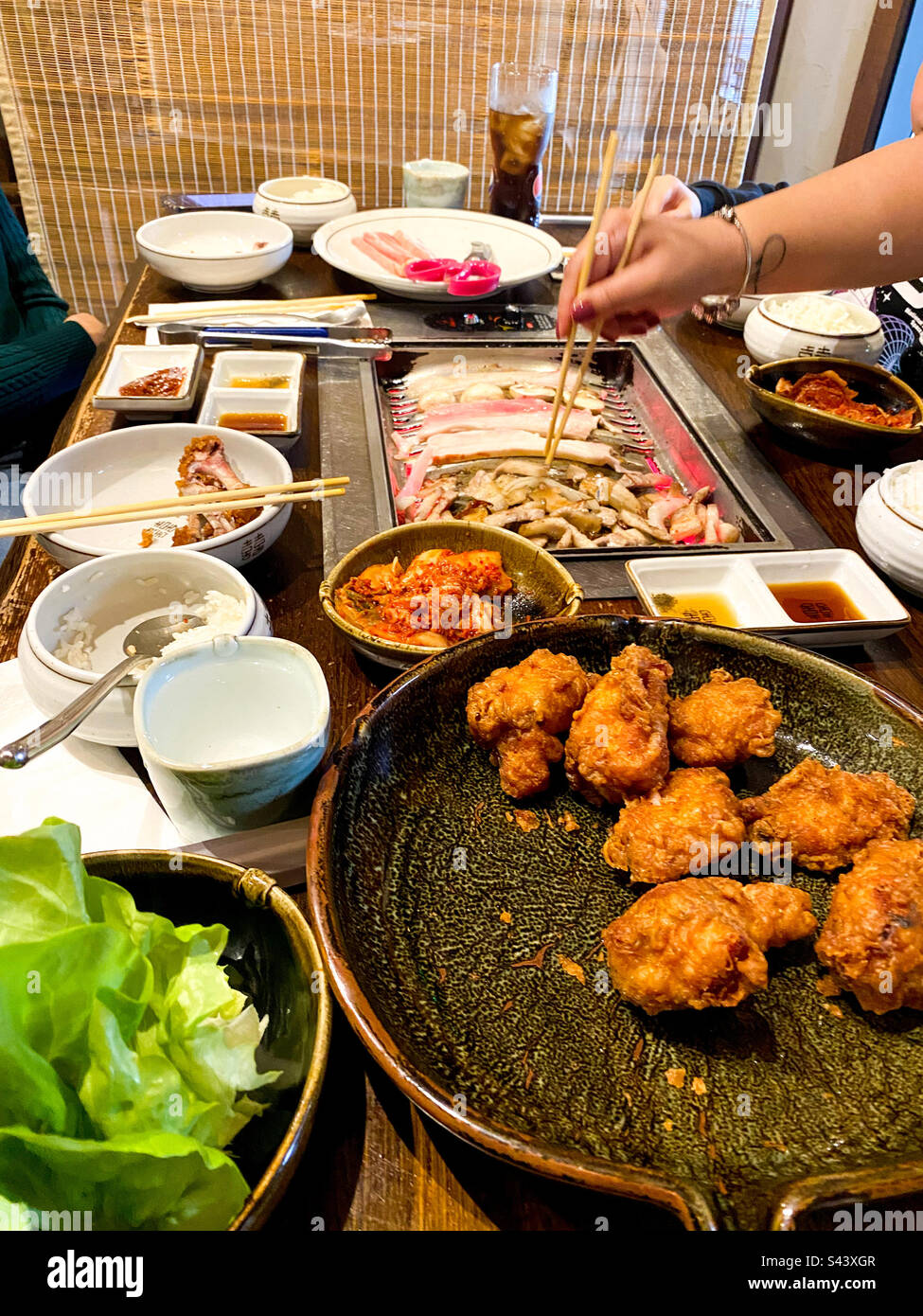 Essen auf einem Tisch in einem koreanischen Restaurant inklusive koreanischem Barbecue und gebratenem Hähnchen. Stockfoto