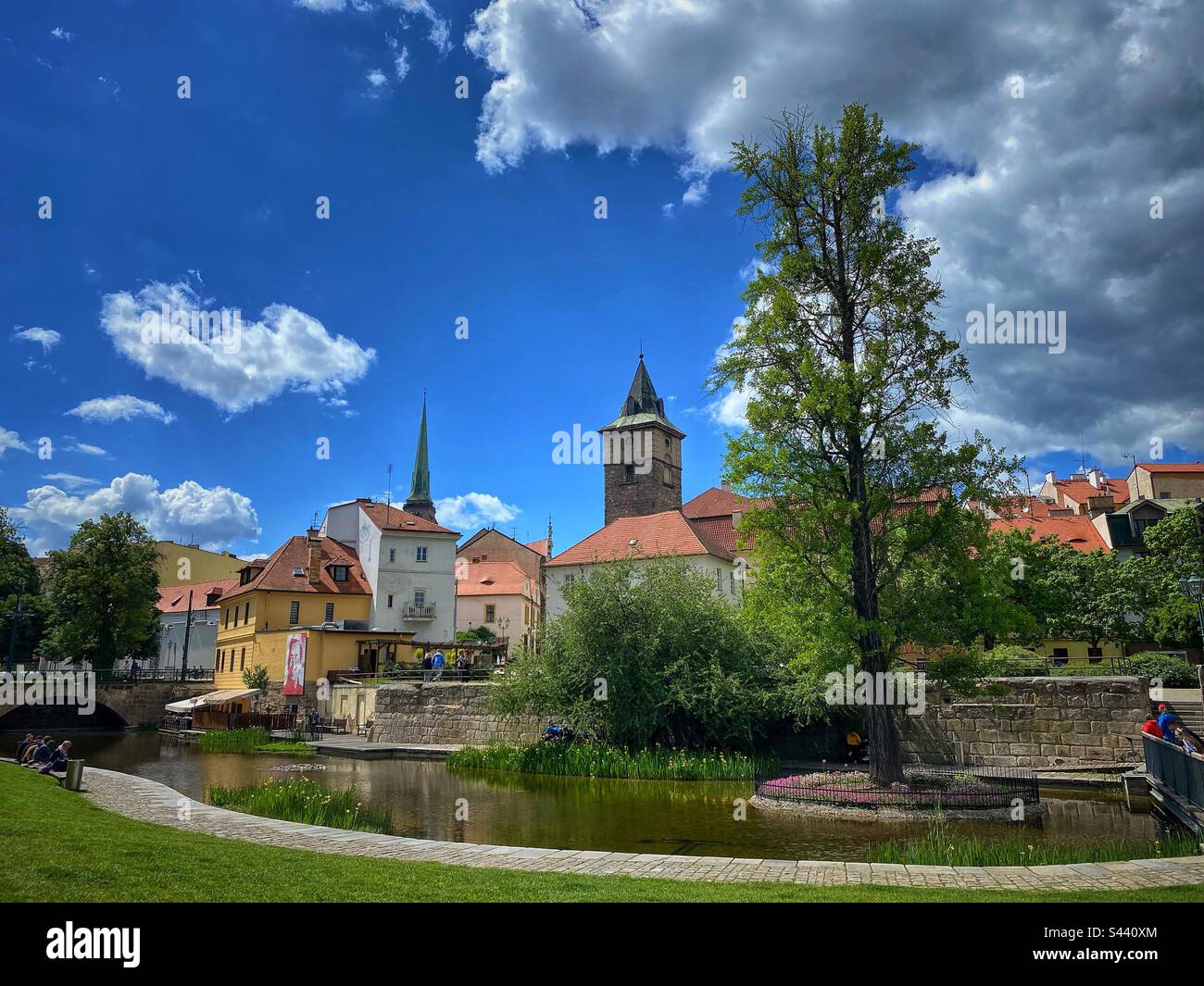 Kleiner Stadtpark „Mlýnská strouha“ mit Wasser und Blick auf die historischen Gebäude in Pilsen, Tschechische Republik. Stockfoto