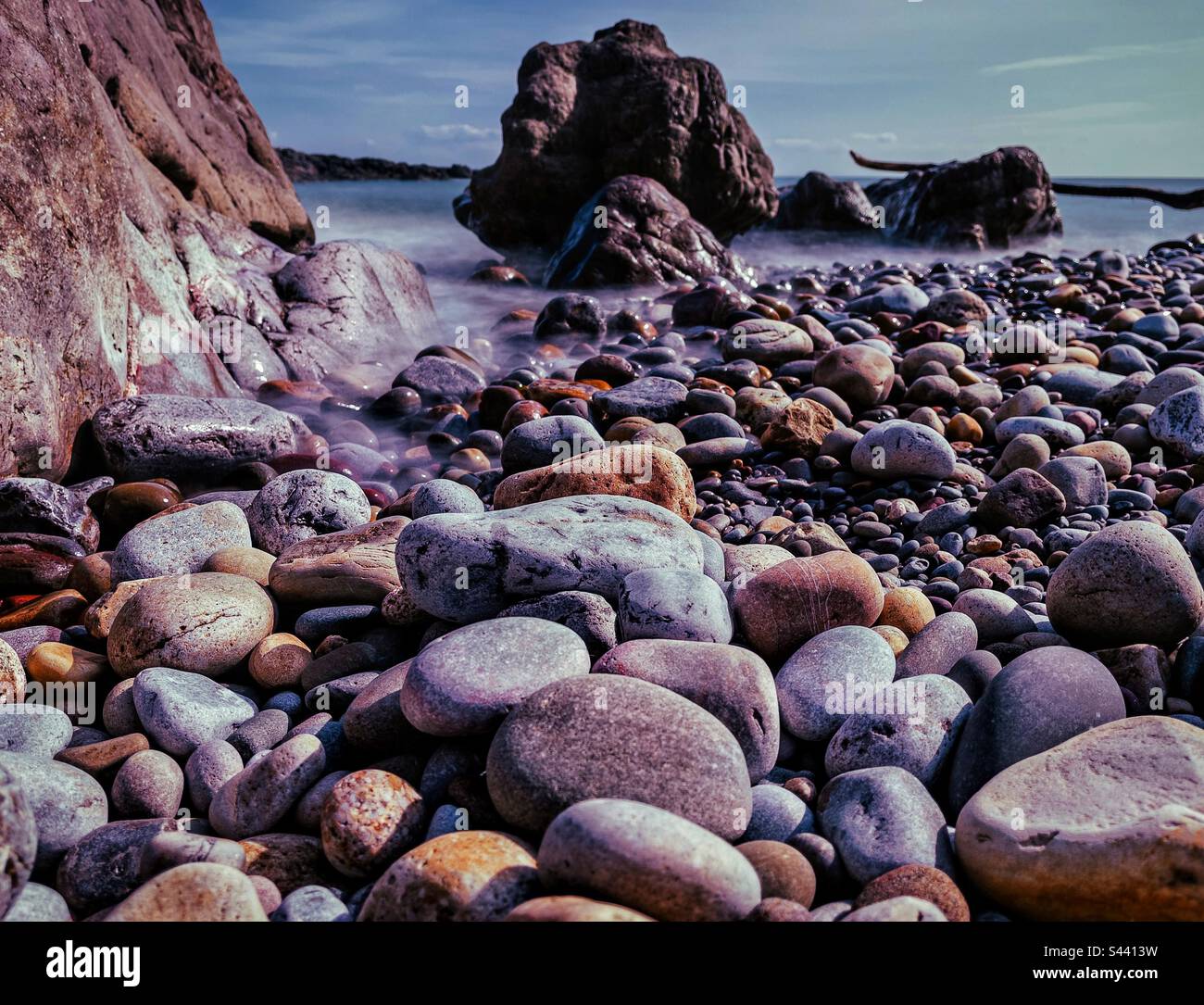 Kieselsteine am Strand, mit langen Gezeiten. Stockfoto