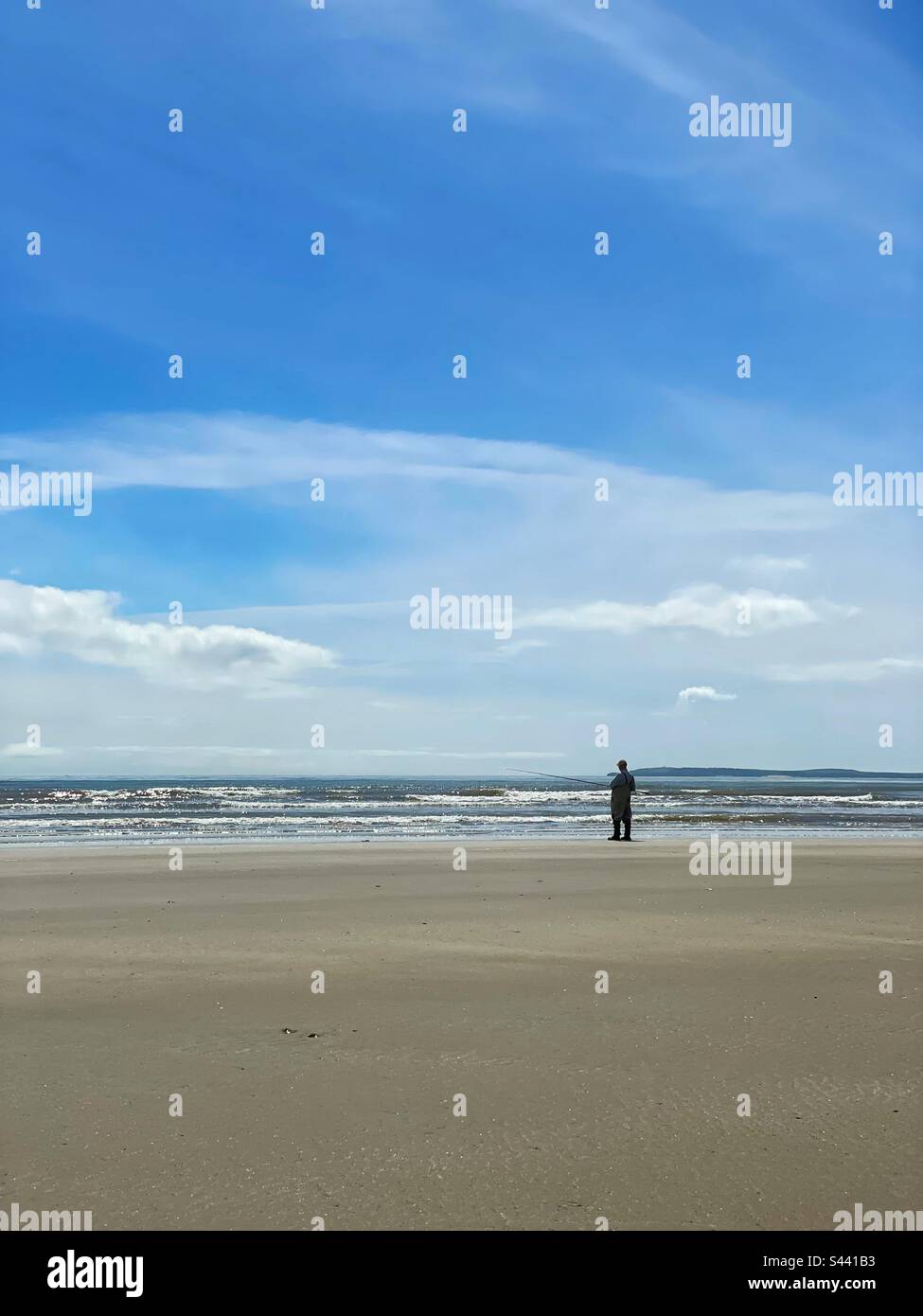 Einsamer Angler, Marros Beach, West Wales. Stockfoto