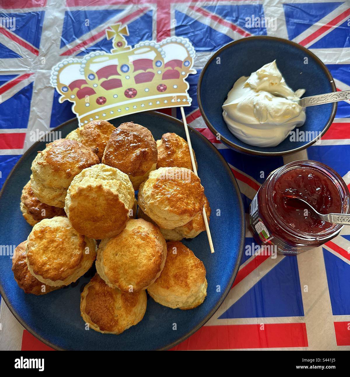 Cream Tea on Krönung Weekend, Scones mit Marmelade und Creme auf einem Union Jack Tischtuch Stockfoto